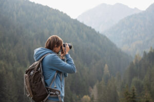 Man Taking Photos of Mountains