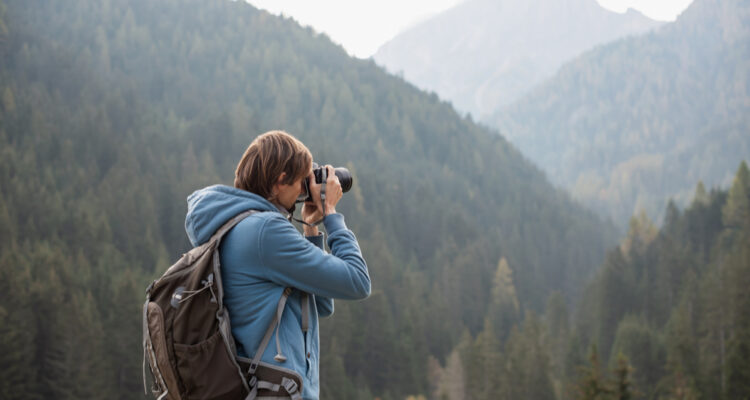 Man Taking Photos of Mountains