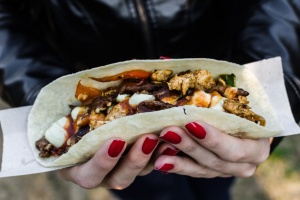 Close up photo of a traditional Mexican taco with beef filling at a street food market. Selective focus.