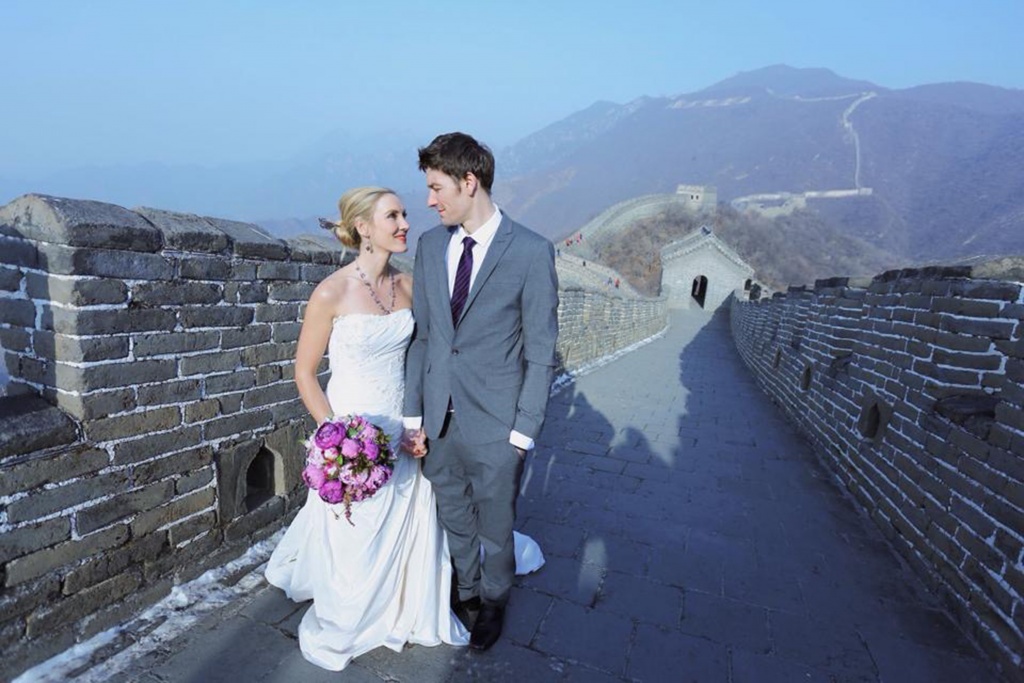 PIC FROM FORTITUDE PRESS (PICTURED - AMELIA AND BRETT GETTING MARRIED AT THE GREAT WALL OF CHINA) A LOVED-UP couple whose wedding plans were dashed after they clashed with a family member’s marriage have gone on to tie the knot in EIGHT different countries. Amelia Irwin, 32, was faced with a dilemma after her wedding was planned in the same month as that of a family member of her partner Brett, 33, last year. But the couple, who met nine years ago, decided to tie the knot in a registry office so they could save £10,000 which they went on to use to travel the globe. And since they got married in Trowbridge last year, the couple have been blessed and enjoyed ceremonies at locations across the globe including Paris, Moscow, Beijing and Nepal. SEE FORTITUDE PRESS COPY