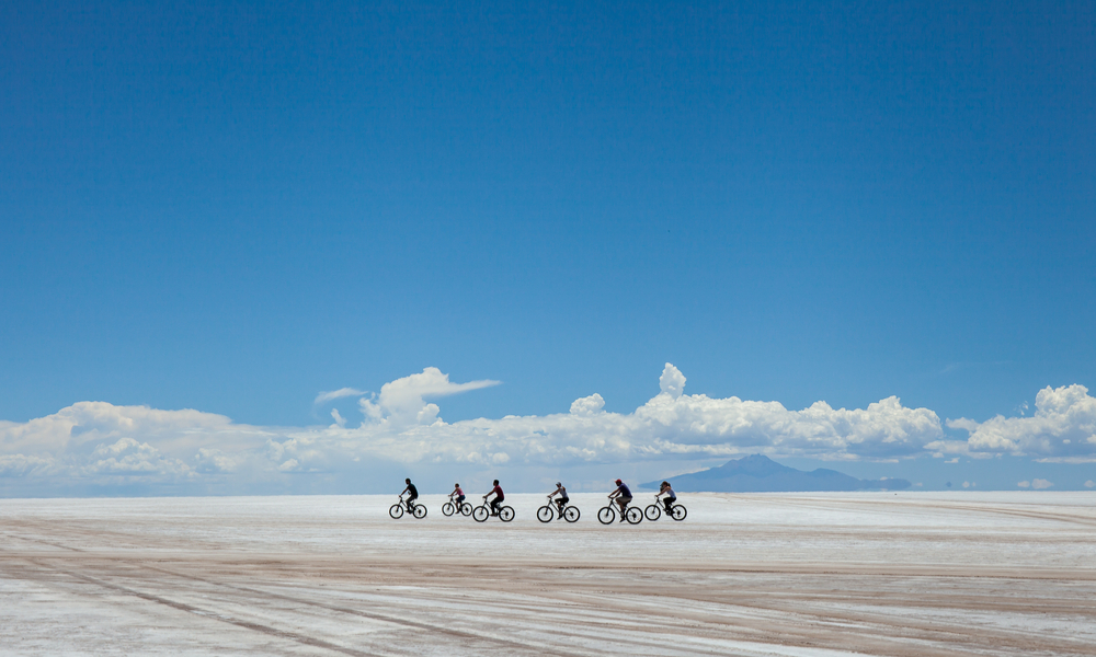 cyclists group riding the desert of salt, in salares de Uyuni, Bolivia. 