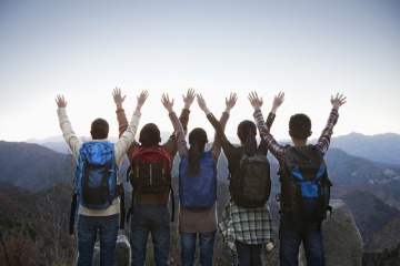 group of hikers with their hands in the air