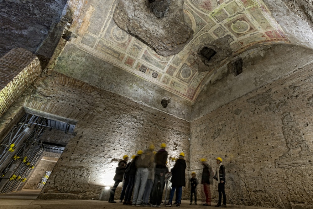 people exploring antique roman ruins being restored