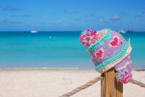 Closeup warm knitted cap on fence at tropical beach