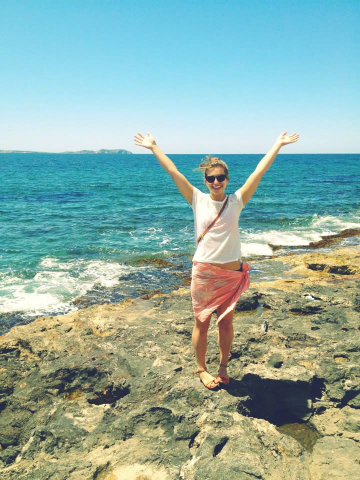 woman standing on rocky beach in ibiza spain