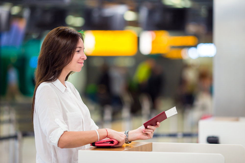 Happy woman with tickets and passports at airport waiting for boarding