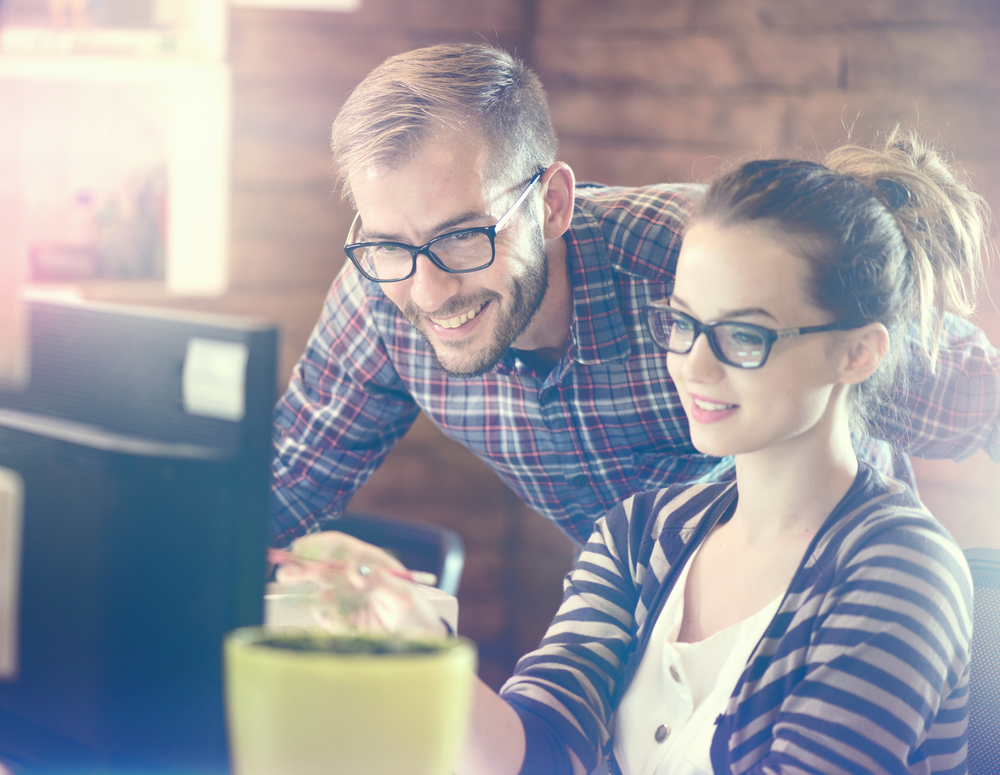 Young Casual business couple using computer in the office. Two colleagues working together on an innovative product design in a creative studio. Coworking, Creative manager showing new startup idea