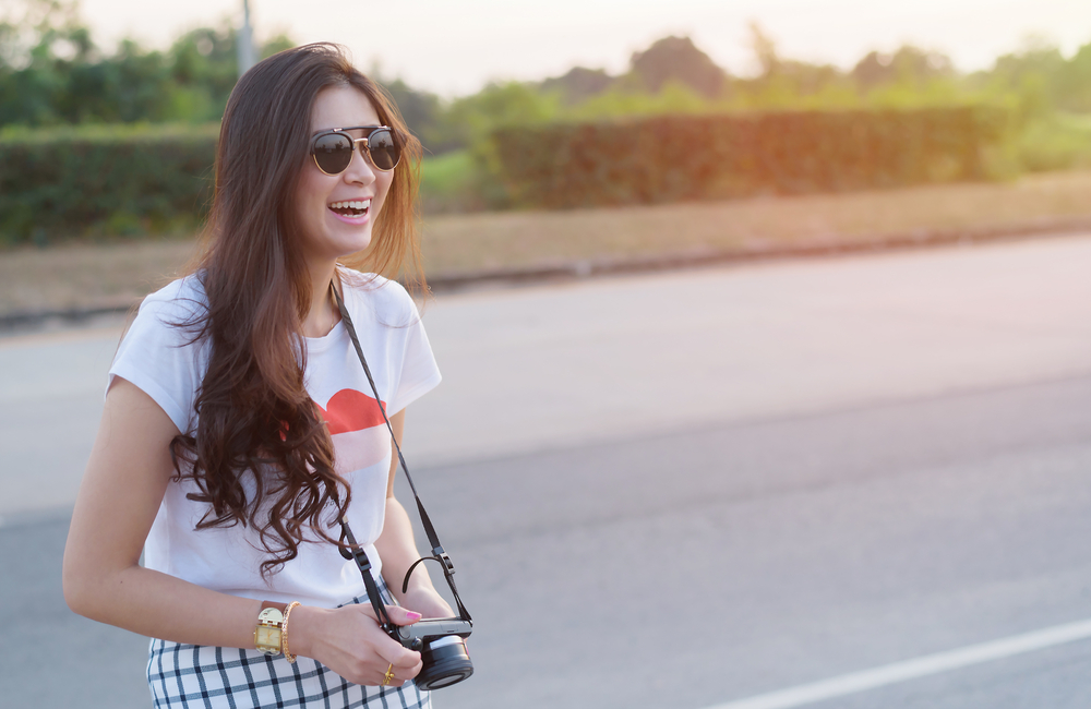 Portrait of Asian woman traveler photography hipster lifestyle on the road with camera