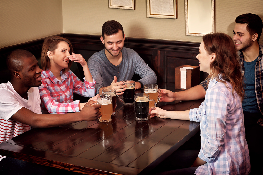 Happy friends drinking beer in pub