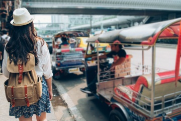 tourist with tuk tuk in the background