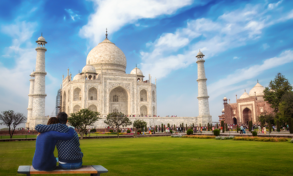 Romantic couple enjoy the view of the Taj Mahal at Agra, India.