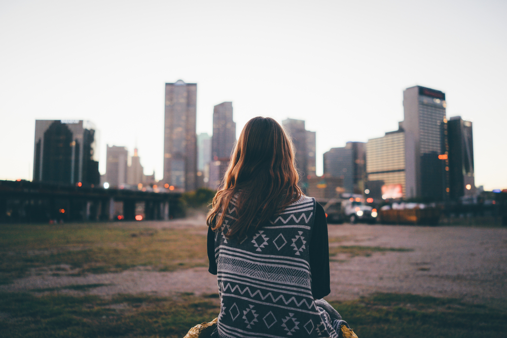 A traveler girl is looking at Dallas skyline during in the evening.