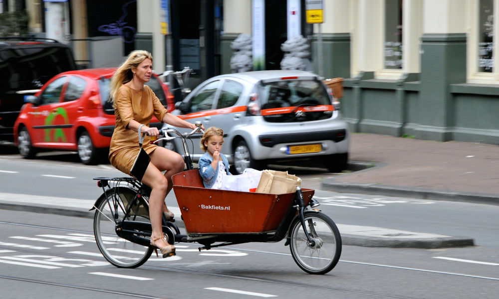 woman riding a bakfiet in amsterdam