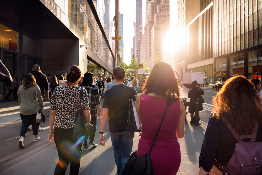 People walking from the work at the street in New York City at sunset time