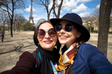 Mother and adult daughter are doing selfie in park in summer going crazy and laughing. Sunset light.Happy and positive emotions.Two friends on vacation.Parents and teenagers.Autumn self-portrait