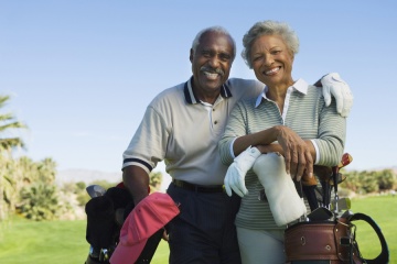 Portrait of happy senior couple in golf course smiling