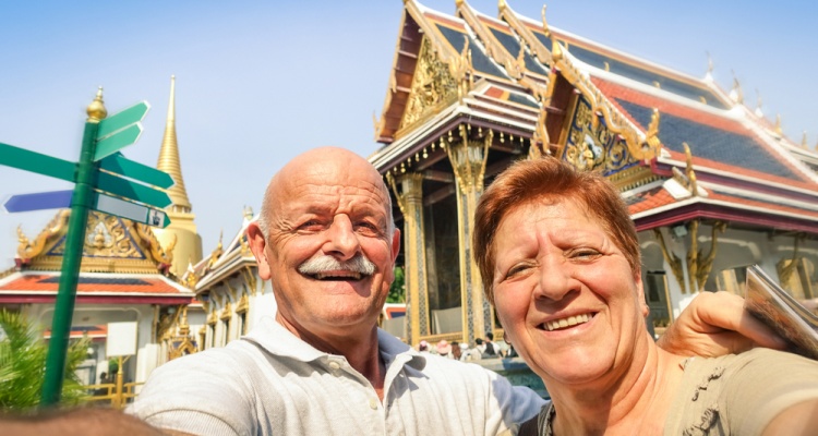 Senior happy couple taking a selfie at Grand Palace temples in Bangkok - Thailand