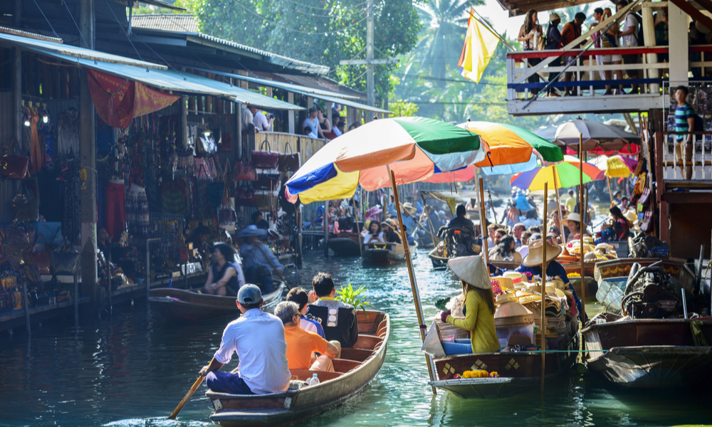 Damnoen Saduak Floating Market, tourists visiting by boat, located in Bangkok, Thailand.