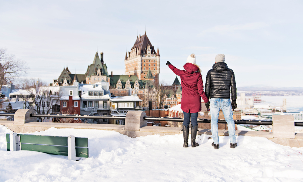 Young couple outside in winter with Quebec city Chateau frontenac