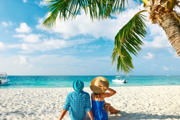 Couple in blue clothes on a tropical beach on a last-minute valentine's day getaway