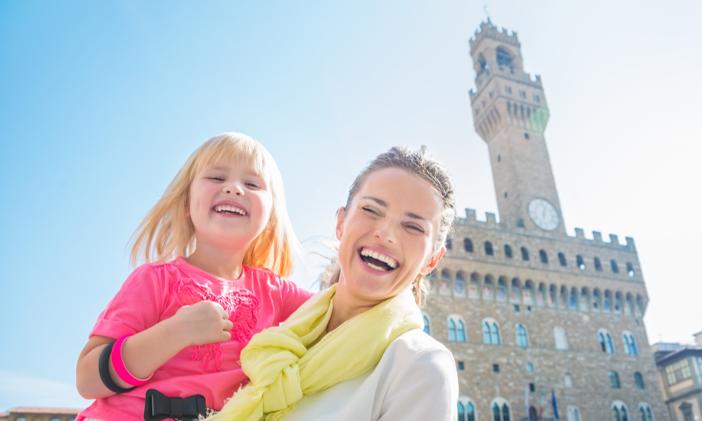 Family discovering old Italian treasures in Florence. Portrait of happy mother and child near Palazzo Vecchio