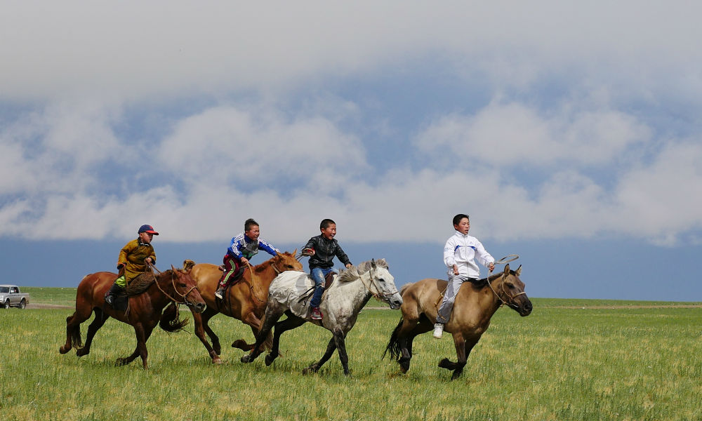 Mongolian children racing their horses