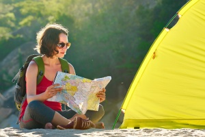 woman looking at a map near campsite