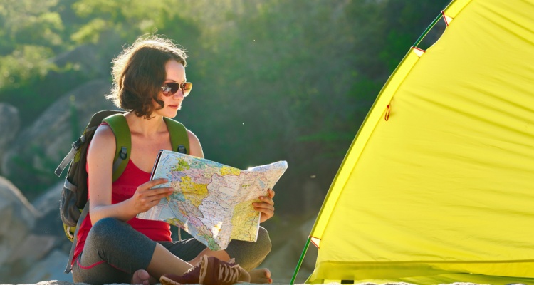 woman looking at a map near campsite