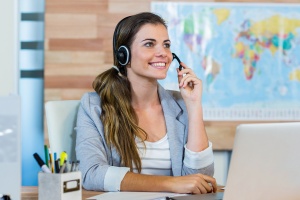 Pretty travel agent speaking to customer in the office