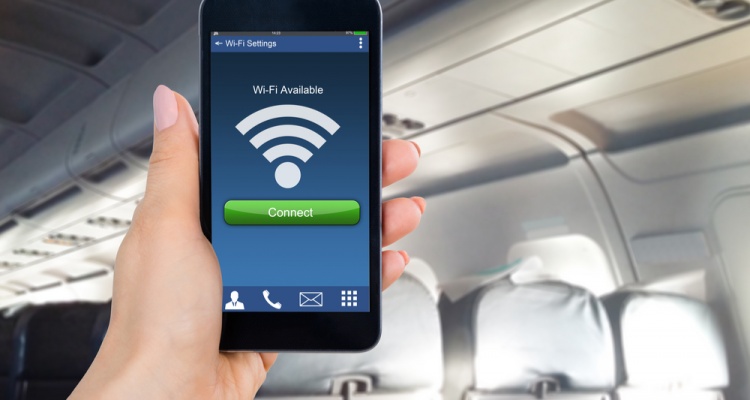 Close-up Of Person's Hand Holding Mobile Phone Showing WiFi Connection In Airplane