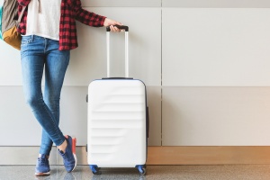 traveler posing with carry on luggage