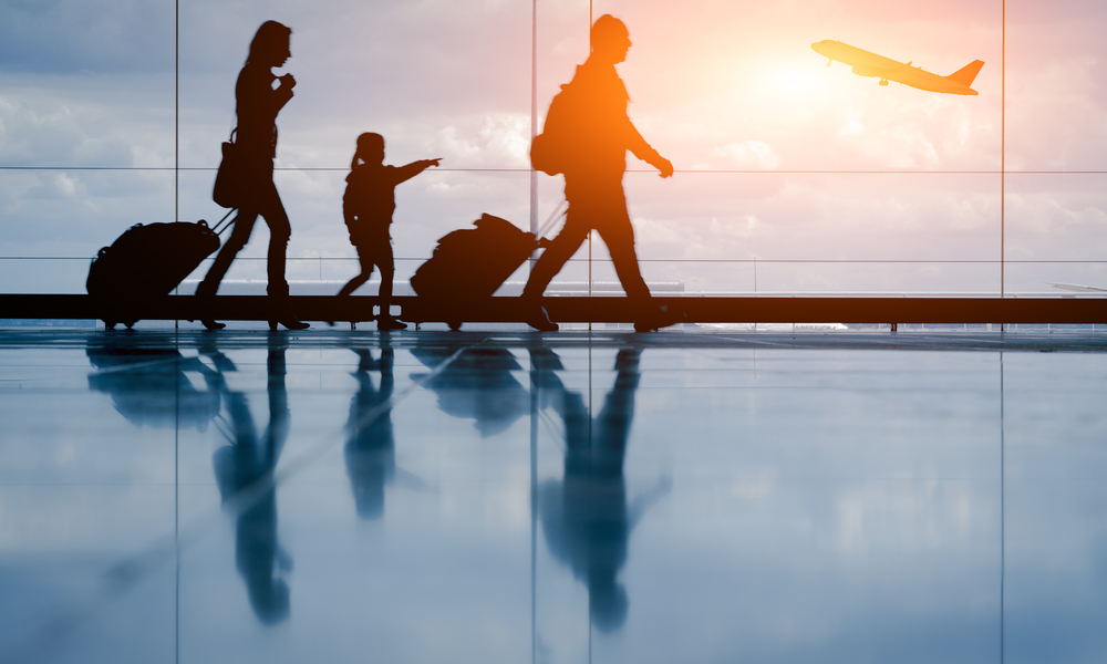 a family rushes through airport with their luggage