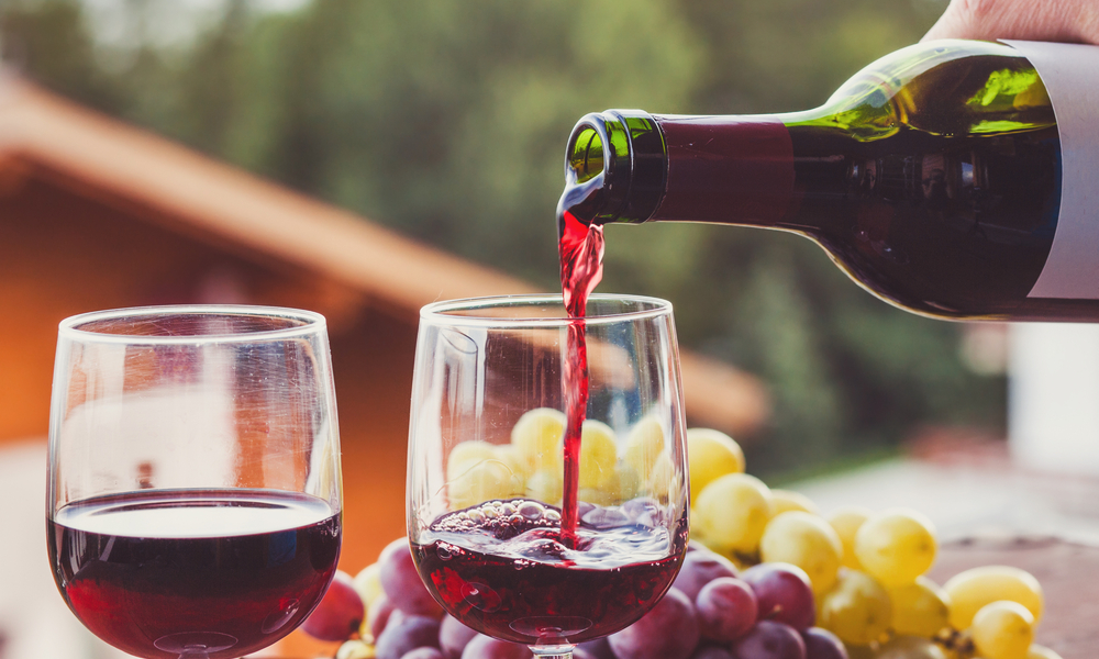 close up of red wine being poured from bottle to glass