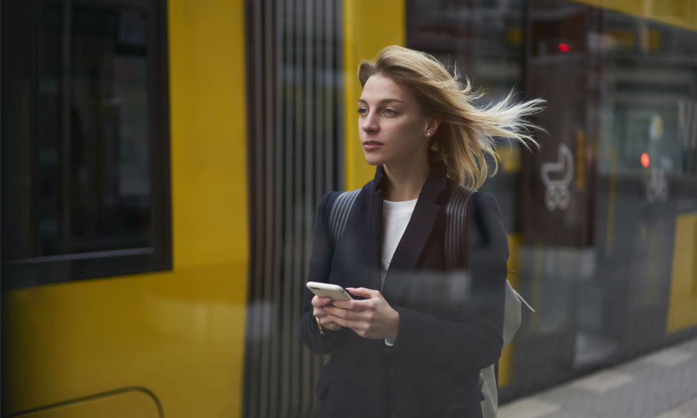 attractive traveler waiting for public transport standing on bus stop