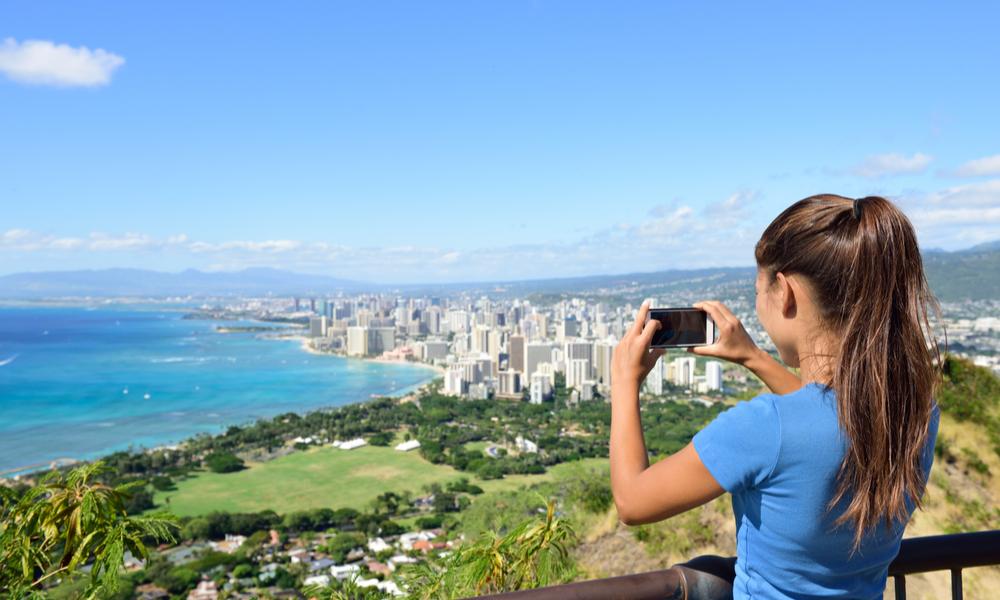 Woman tourist on hike visiting famous viewpoint lookout in Diamond Head State Monument and park, Oahu, Hawaii, USA