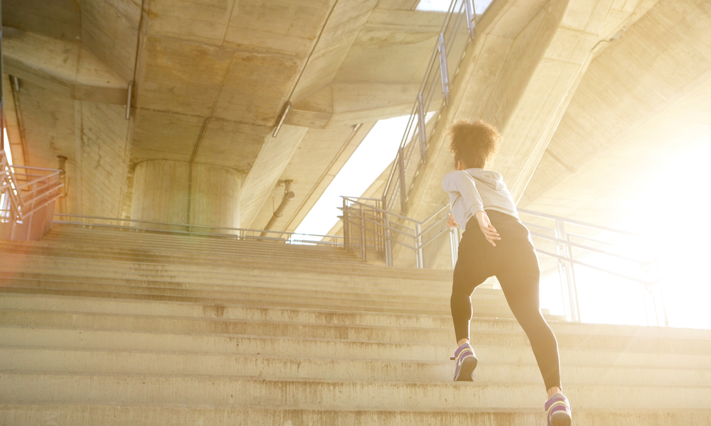 Young woman running alone up stairs