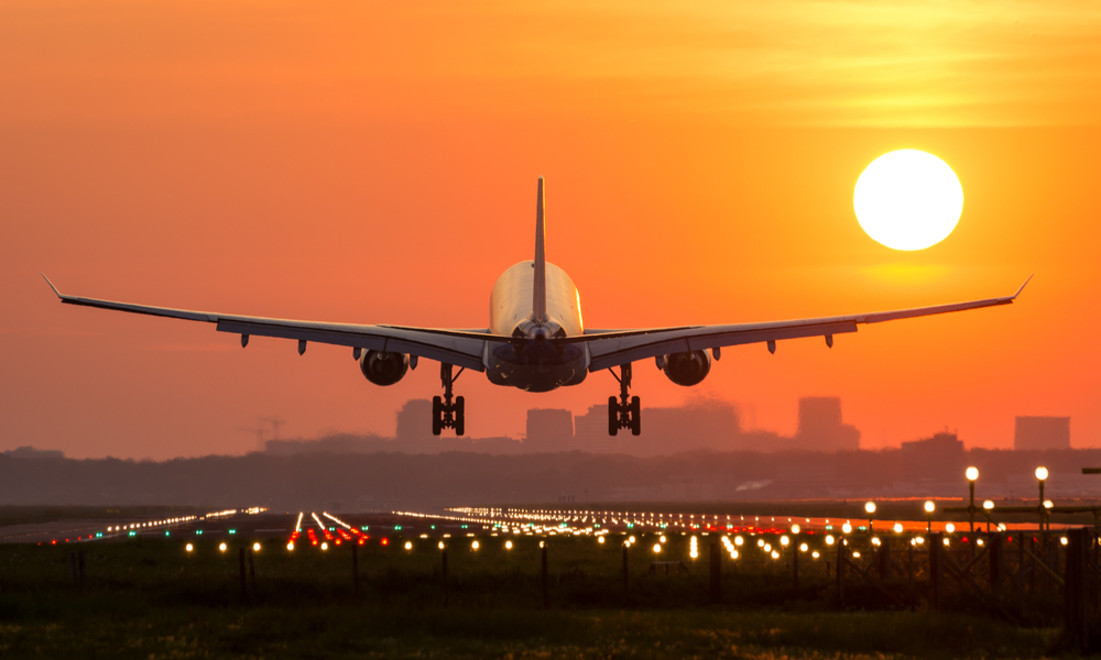 Passenger plane is landing during a wonderful sunrise.