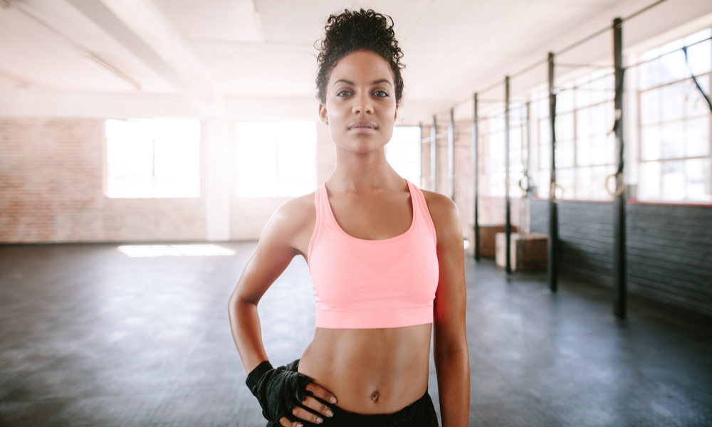 Portrait of confident young woman standing in gym. 