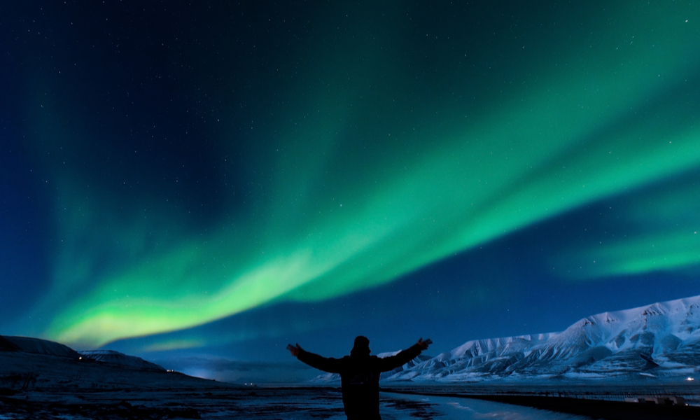 The polar Northern lights in Norway Svalbard in the mountains silhouette of man