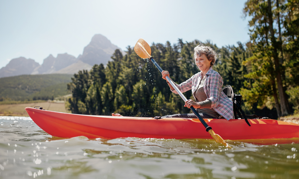 Shot of senior woman kayaking on lake on a summer day.