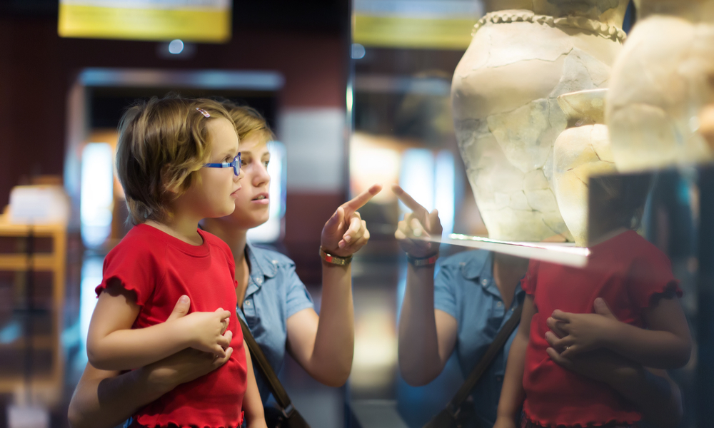 Woman and child looking old ancient amphora in historical museum