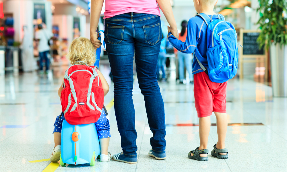 mother and two kids walking in the airport, family travel