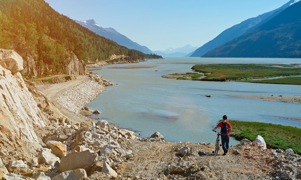 man with bike in mountain landscape in alaska