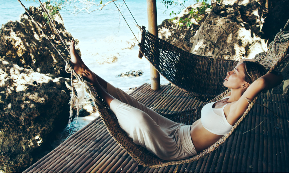 Woman relaxing in the hammock on tropical beach, hot sunny day