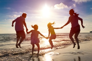 family jumping at the beach