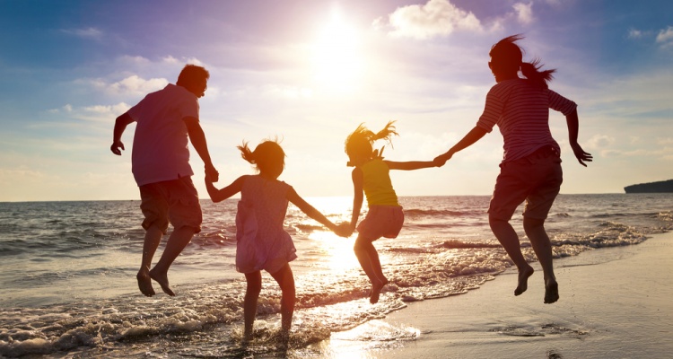 family jumping at the beach