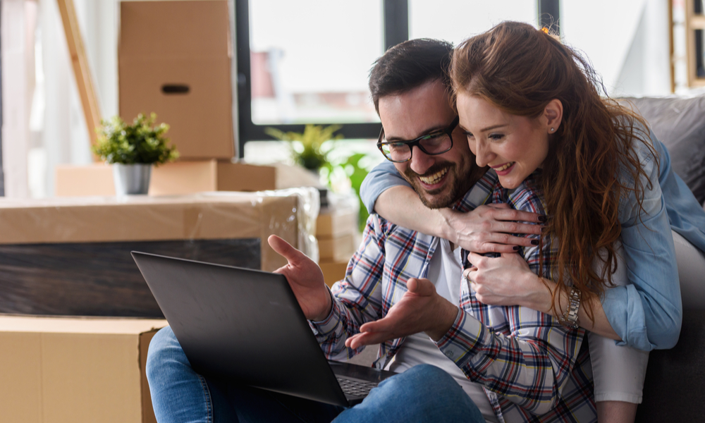 Thanksgiving Travel Myths: couple on laptop happy after finding flight deals for Thanksgiving