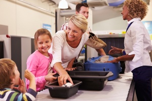 tsa travel tips to get through airport security faster: Family At Airport Passing Through Security Check