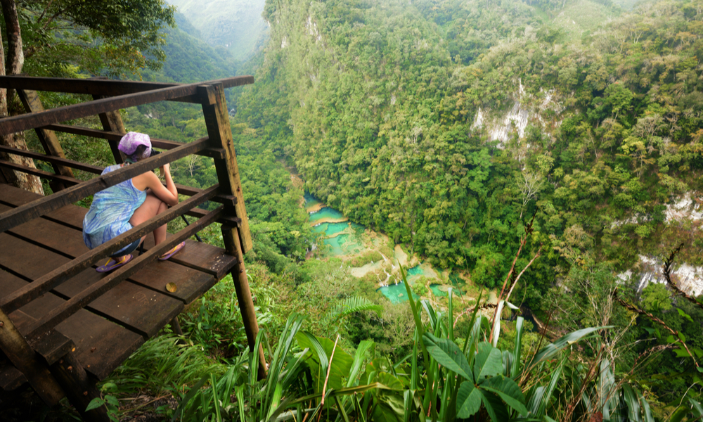 fun places to go visit in 2020: Photographer on the lookout point on the Cascades National Park in Guatemala Semuc Champey