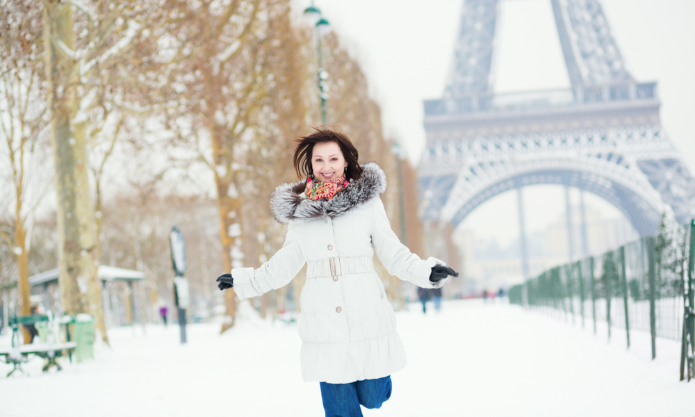 How to do paris on a budget: Girl happily jumping in Paris on a winter day